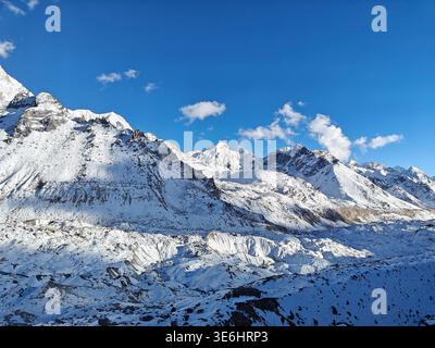 Maestose montagne himalayane in Nepal con cime innevate e cielo azzurro. Foto Stock