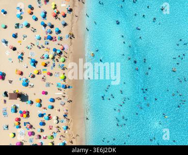 Vista aerea di ombrelloni colorati sulla spiaggia sabbiosa, persone che nuotano Foto Stock