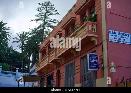 ICOD DE LOS VINOS, TENERIFE, SPAGNA – 19 OTTOBRE 2025: Un edificio rosa salmone con balconi ornati a Icod de los Vinos, con cartelli per Bar Socas tapa Foto Stock
