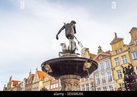 Danzica, Polonia - 2 maggio 2025: Fontana del Nettuno nella Piazza del mercato lungo. Maestosa fontana di bronzo con Nettuno che tiene in mano il suo tridente. L'arco ornato Foto Stock