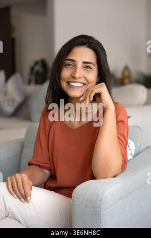 Bella giovane donna in abiti informali che si rilassa in una comoda poltrona Foto Stock