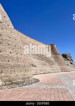 Massiccio muro esterno e approccio inclinato accanto all'Arca di Bukhara a Bukhara, Uzbekistan. Foto Stock