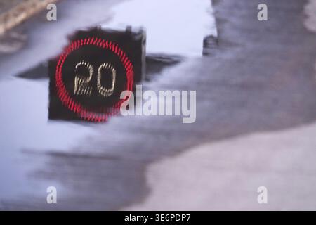 Segnale stradale con limite di velocità riflesso sulla strada, Germania Foto Stock