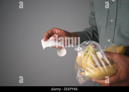 Persona che detiene banane e ricevuta Foto Stock