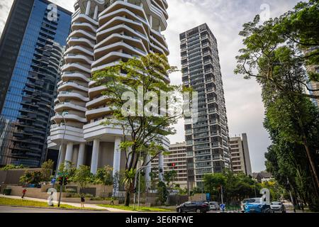 Moderni grattacieli residenziali con architettura organica unica nel centro di Singapore durante il giorno. Vista stradale ad angolo basso con facciate in vetro, Foto Stock