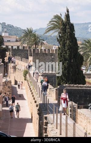Persone che camminano lungo le mura medievali della città di Alcudia, Maiorca Foto Stock