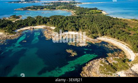 Uno splendido panorama aereo del Parco naturale di Carreirón. Le acque cristalline turchesi si insinuano su piccole insenature di sabbia bianca, circondate da una densa prua di pino Foto Stock