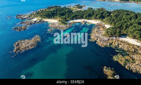 Uno splendido panorama aereo del Parco naturale di Carreirón. Le acque cristalline turchesi si insinuano su piccole insenature di sabbia bianca, circondate da una densa prua di pino Foto Stock