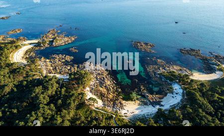 Splendida prospettiva aerea del Parco naturale di Carreirón sull'Illa de Arousa. Le acque cristalline turchesi si insinuano su calette di sabbia bianca, circondate da un Foto Stock