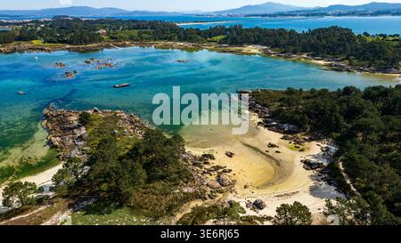 Splendida prospettiva aerea del Parco naturale di Carreirón A Illa de Arousa. Le acque cristalline turchesi si insinuano su calette di sabbia bianca circondate da lu Foto Stock