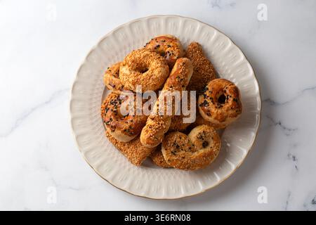 Biscotti salati turchi assortiti con semi di sesamo e Nigella serviti su un piatto bianco Foto Stock