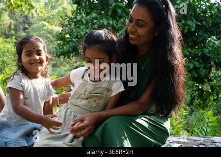 Madre indiana e i suoi due figli si godono il tempo in famiglia insieme nella natura Foto Stock