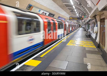 Il confuso treno della metropolitana di Londra si muove velocemente attraverso una stazione. Londra, Regno Unito, 9 settembre 2023 Foto Stock
