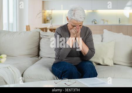 Triste stanco malato solo deluso anziana donna seduta a casa da solo. Nonna matura infelice che sperimenta dolore relativa morte cattiva notizia. Stressato anziana che soffre di solitudine Foto Stock