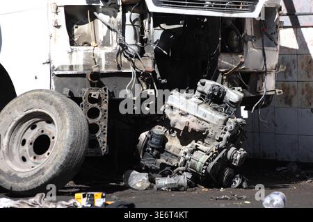 Motore e parti del veicolo smontati in un'officina di recupero automatico o di riparazione Foto Stock