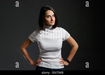 Giovane donna seria che posa in studio Foto Stock