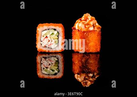 Due sushi roll, un California roll ricoperto di caviale rosso tobiko che mostra carne di granchio e sezione trasversale di cetrioli, un tempura fritta in profondità Foto Stock