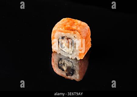 Due sushi involtini avvolti nel salmone, uno con sezione trasversale e ripieno di anguille grigliate e formaggio spalmabile, uno cotto con una parte dorata croccante e sale marino, Foto Stock