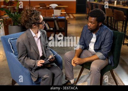 Uomo e donna discutono del progetto in ufficio Foto Stock