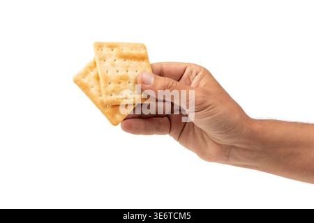 Maschio che tiene in mano il biscotto cremoso su sfondo bianco Foto Stock