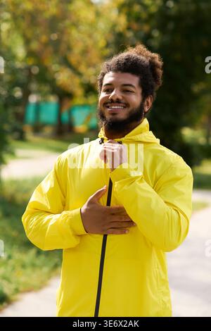 L'uomo afroamericano sorride mentre si prepara per un allenamento all'aperto in una giornata primaverile Foto Stock