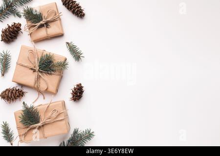 Bordo di regali di natale e coni di pino su bianco Foto Stock