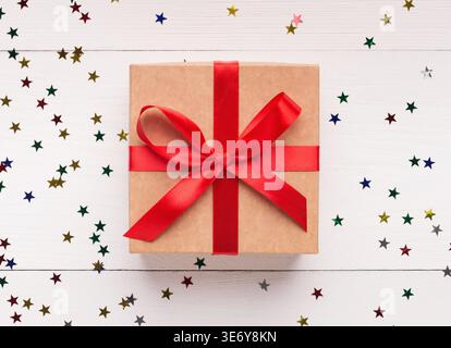 Confezione regalo marrone con fiocco rosso su sfondo bianco Foto Stock