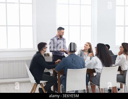 Allegri uomini d'affari che discutono di un contratto di successo in ufficio Foto Stock