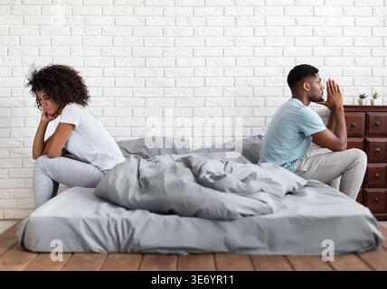 Coppia seduta a letto durante il conflitto Foto Stock