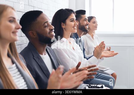 Un gruppo di uomini d'affari che si battono per mano durante la riunione Foto Stock