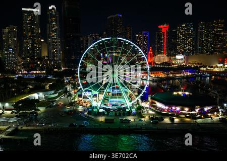 Miami, FL, Stati Uniti - 8 febbraio 2026: Skyviews Miami Ferris Wheel che crea riflessi colorati sull'acqua con lo skyline della città Foto Stock