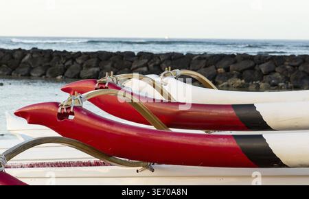 La mattina presto sorgere del sole all'alba illumina outrigger del tradizionale canoa Hawaiiana in Waikiki Beach area di Oahu in Hawaii Foto Stock