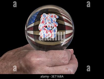 Mano dell'uomo caucasico superiore che tiene i tellers di fortuna del vetro globo o. Palla per prevedere il risultato delle elezioni presidenziali degli Stati Uniti Foto Stock
