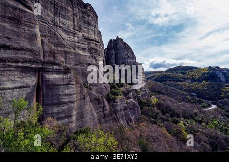 Il pittoresco Sacro Monastero di Rousanos costruito in cima a una snella colonna di roccia a Meteora, Grecia. Circondato da vegetazione lussureggiante e scogliere spettacolari, questo hotel Foto Stock