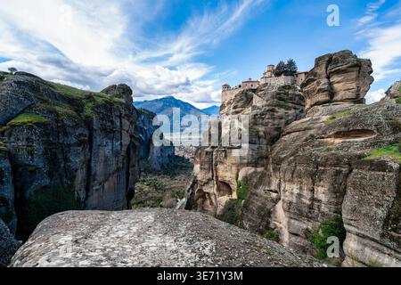 Monastero di Varlaam arroccato su torreggianti colonne di roccia a Meteora, Grecia. Paesaggio spettacolare con architettura storica ortodossa, sfondo di montagna, e. Foto Stock