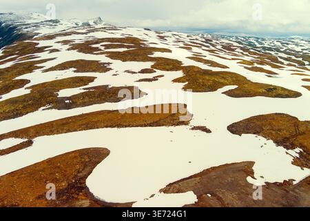 Vista aerea delle montagne innevate in estate. Strada di alta montagna Bjorgavegen. Aurlandsvegen, Aurland, Norvegia Foto Stock