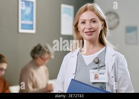 Ritratto di Dottore donna di mezza età in piedi in clinica Foto Stock