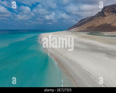 Vista aerea della laguna turchese che incontra le sabbie bianche a contrasto con l'aspra costa rocciosa, la laguna di Detwah, Socotra, Yemen. Foto Stock