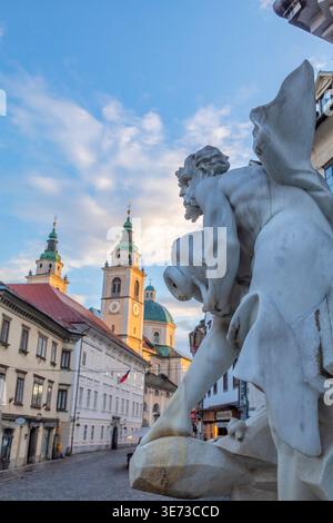 Dettaglio della Fontana di Robba (Fontana dei tre fiumi Carniolani) con la Cattedrale di Lubiana sullo sfondo, Lubiana, Slovenia Foto Stock
