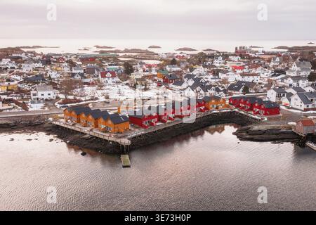 Vista aerea delle case colorate in contrasto con il paesaggio grigio e le acque calme, Ballstad, Nordland, Norvegia. Foto Stock