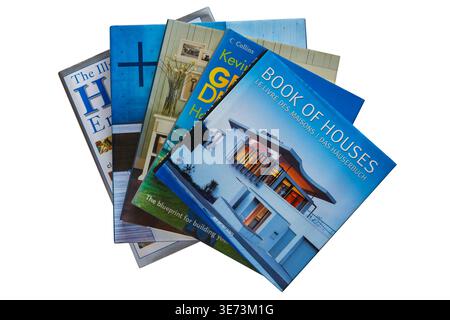 Un mucchio di libri cartacei su case e case con libro Book of Houses in cima isolato su sfondo bianco Foto Stock