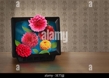 Vecchio televisore con fiori sul tavolo vicino alla parete. Poster creativo Foto Stock