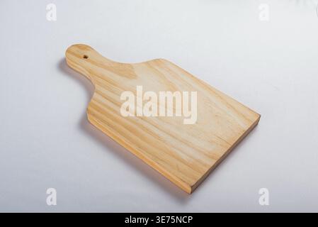 Foto in studio con configurazione minimalista. Un'illuminazione uniforme e uniforme esalta la consistenza del tagliere in legno. Da utilizzare per cucinare, presentare il cibo, cucinare Foto Stock