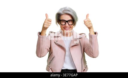 Donna anziana che sorride e fa un gesto di due pollici Foto Stock
