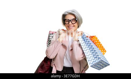 Donna anziana felice che si diverte a fare shopping con le borse Foto Stock
