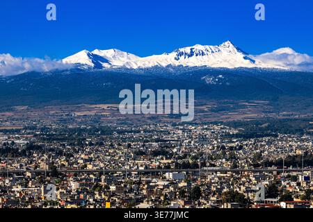 Vulcano Nevado de Toluca innevato (Xinantécatl), a 4.680 metri sul livello del mare, che si innalza sopra la città di Toluca de Lerdo, capitale dello Stato di me Foto Stock