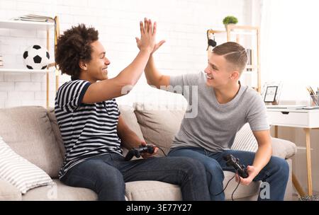 Amici felici che celebrano la vittoria nei videogiochi Foto Stock