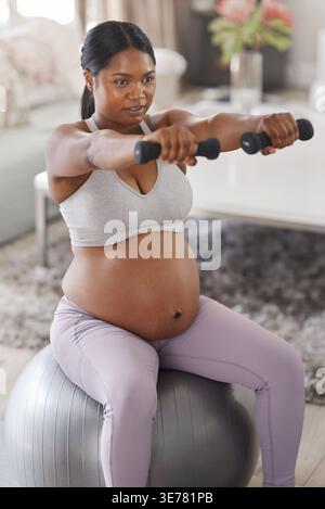Donna incinta, manubri e palla medica in casa per fitness, allenamento di forza ed equilibrio. Donna, gravidanza e attrezzatura prenatale Foto Stock