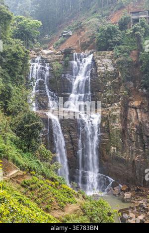 Cascata Ramboda vicino alla città di Nuwara Eliya nello Sri Lanka. Maestosa cascata a più livelli, immersa nel verde lussureggiante paesaggio montagnoso e Rocky Outcro Foto Stock