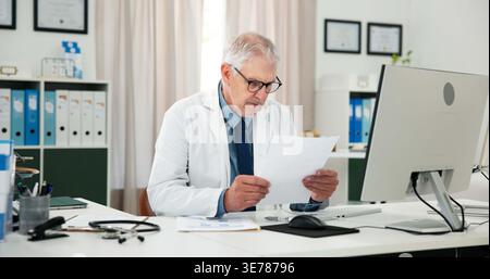 Documenti, medico e lettura con l'uomo in ufficio di ospedale per rapporto, diagnosi medica o ricerca. Esperto di assistenza sanitaria, documenti o trattamenti Foto Stock